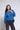 Woman wearing a blue sweatshirt with 'University of Saint Francis Cougars' text, standing against a white background.