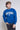Person wearing a blue 'University of Saint Francis' sweatshirt on a plain background